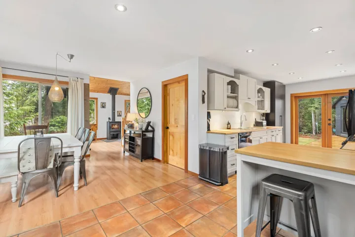 Kitchen with a kitchen breakfast bar, recessed lighting, a wood stove, hanging light fixtures, and a sink