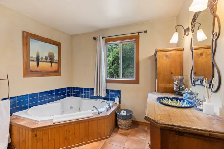 Bathroom featuring a sink, tile patterned flooring, and a jetted tub