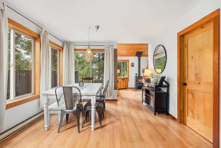 Dining space with a wood stove, light wood-type flooring, and plenty of natural light