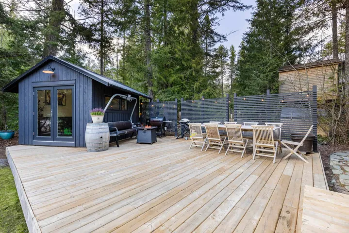 Deck with fence, french doors, area for grilling, outdoor dining space, and an outdoor structure