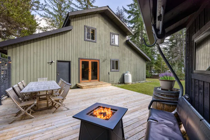 Wooden deck featuring outdoor dining space, a fire pit, and french doors