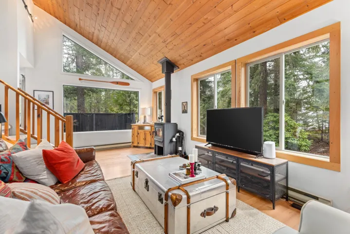 Living area with a wealth of natural light, wood finished floors, a wood stove, and wood ceiling