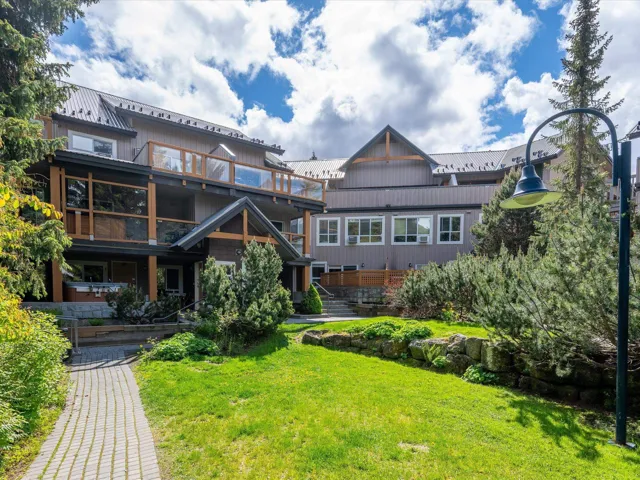 Back of house with a lawn and metal roof