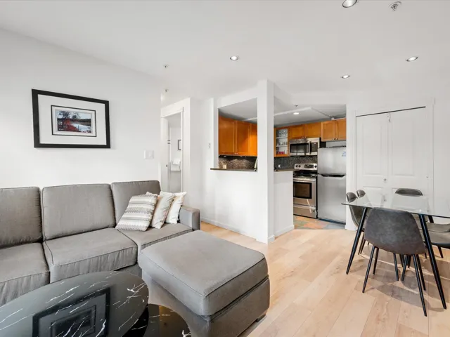Living area with light wood finished floors and recessed lighting