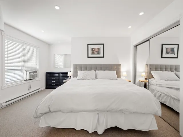 Bedroom with a baseboard heating unit, carpet floors, recessed lighting, cooling unit, and a closet