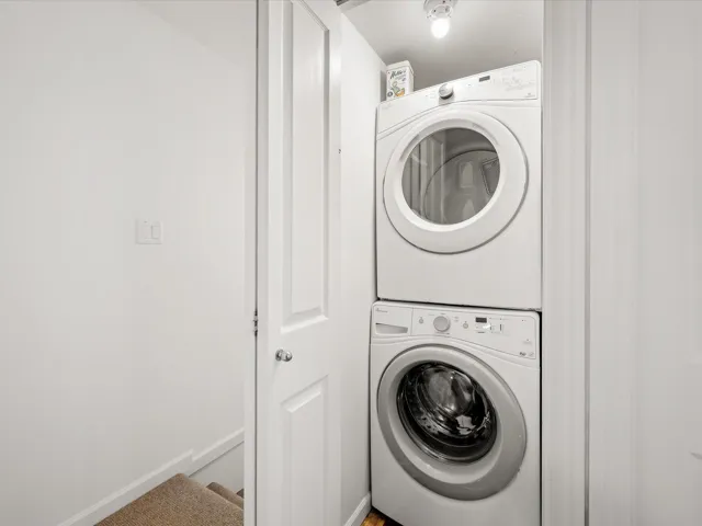 Washroom featuring stacked washer / drying machine