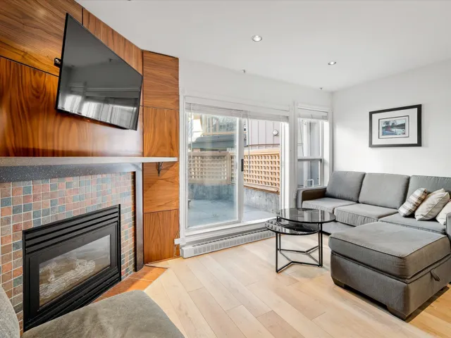 Living area featuring light wood-style flooring, recessed lighting, and a fireplace