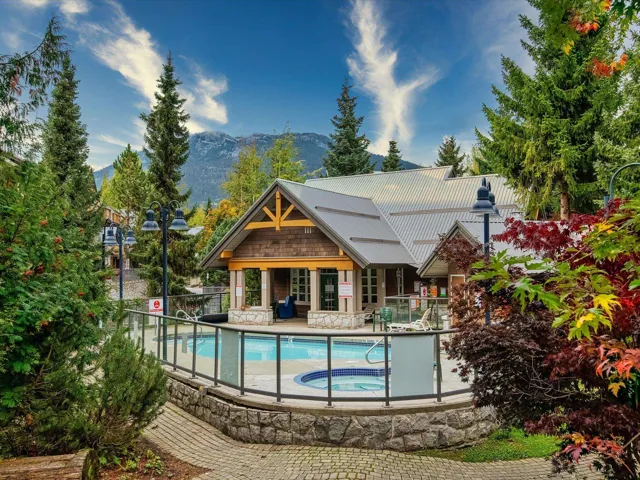 Back of house with a hot tub, a community pool, a mountain view, a patio area, and metal roof