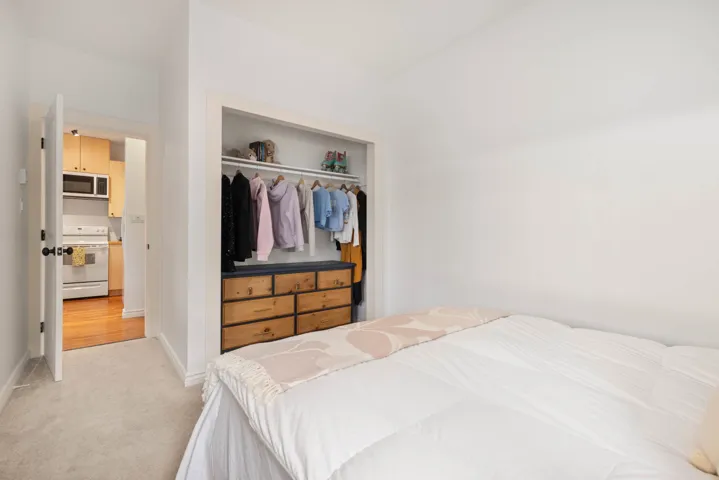 Bedroom with light carpet, baseboards, and a closet