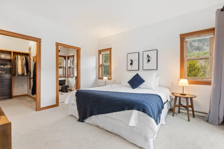 Carpeted bedroom with a baseboard heating unit, a closet, multiple windows, and a spacious closet