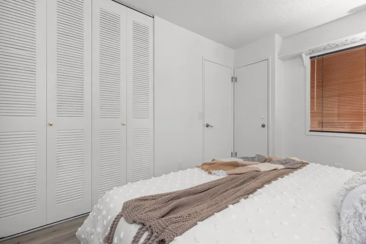 Bedroom featuring a textured ceiling, a closet, and wood finished floors
