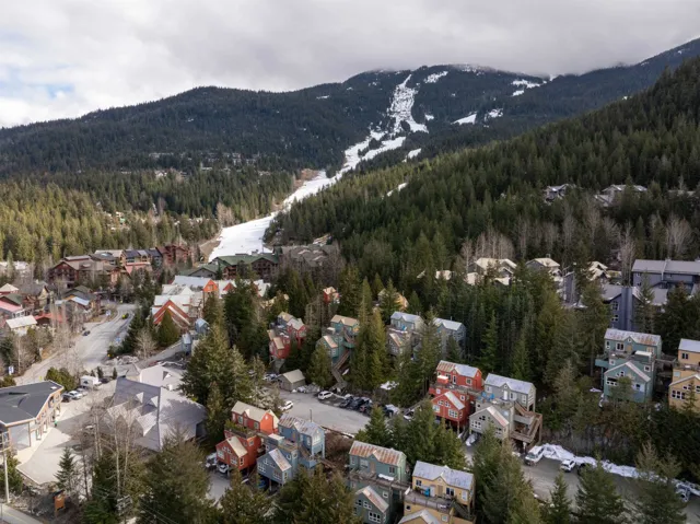 Aerial overview of property's location featuring a mountainous background and nearby suburban area