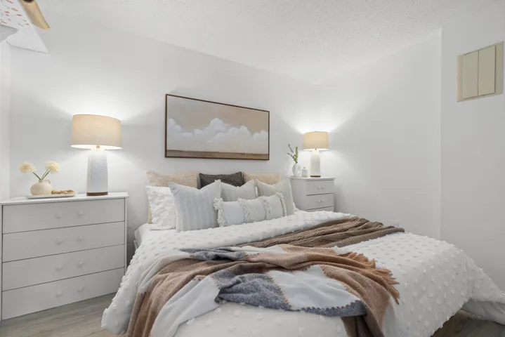 Bedroom with wood finished floors and a textured ceiling
