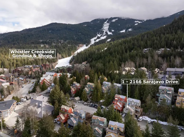 Aerial view of property and surrounding area with a forest and nearby suburban area