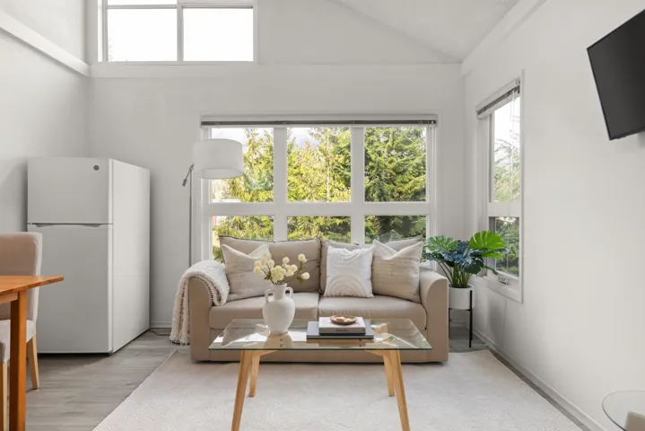 Living area featuring lofted ceiling, light wood-style floors, and plenty of natural light