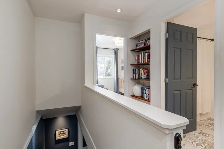 Hall featuring built in shelves and an upstairs landing