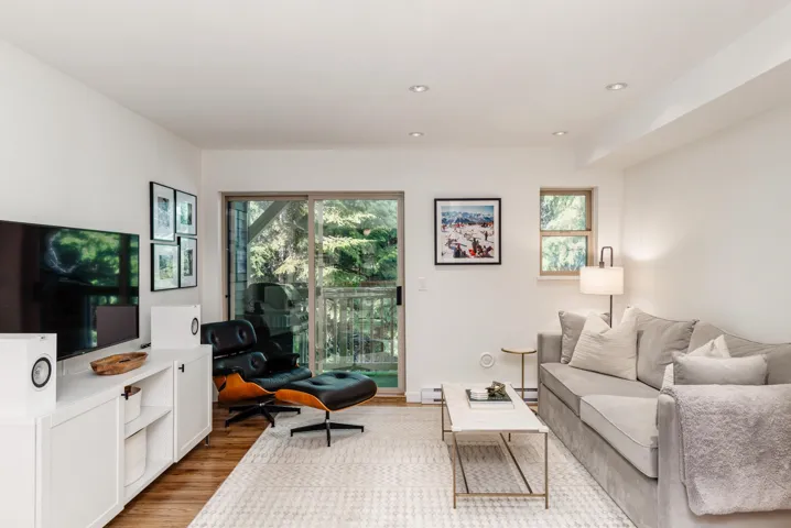 Living area featuring wood finished floors, a baseboard heating unit, and plenty of natural light