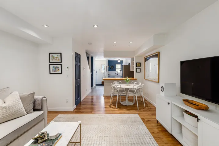 Living room with light wood-style floors, recessed lighting, and baseboards