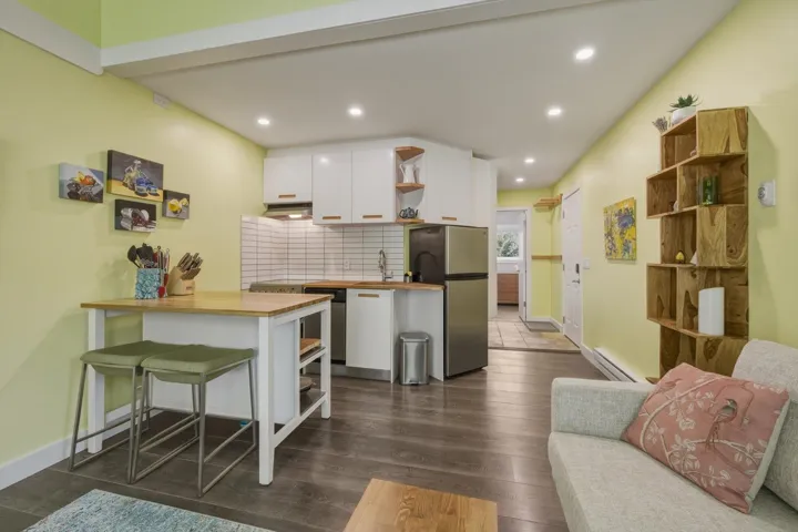 Compact kitchen area featuring white cabinetry, stainless steel appliances, and a tiled backsplash