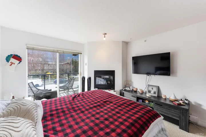 Bedroom featuring a glass covered fireplace and access to outside