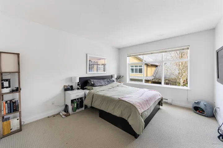 Carpeted bedroom with a baseboard radiator and baseboards