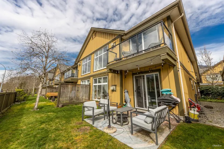 Rear view of property with a yard, a balcony, a patio area, and fence