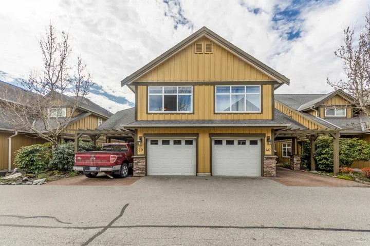 View of front of property with roof with shingles, an attached garage, stone siding, and aphalt driveway