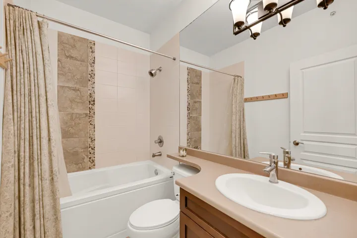 Full bathroom with shower / bath combo, toilet, and vanity