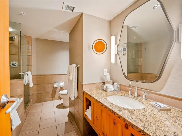 Bathroom featuring vanity, tile patterned flooring, visible vents, toilet, and a stall shower