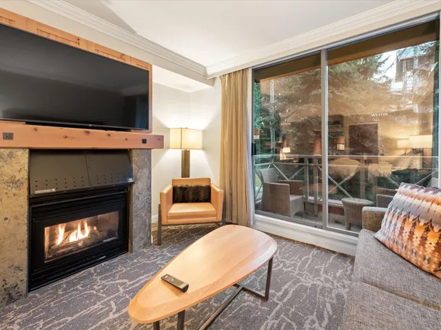 Living area featuring a glass covered fireplace and crown molding