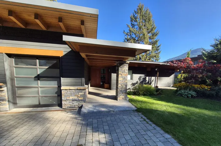 View of front of home with stone siding and a front lawn