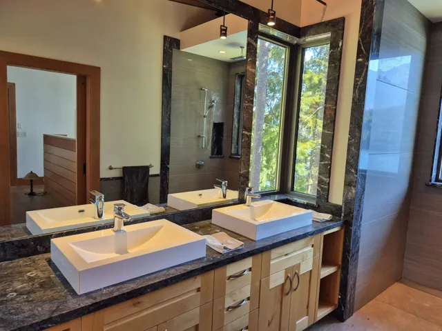 Bathroom featuring double vanity and a tile shower