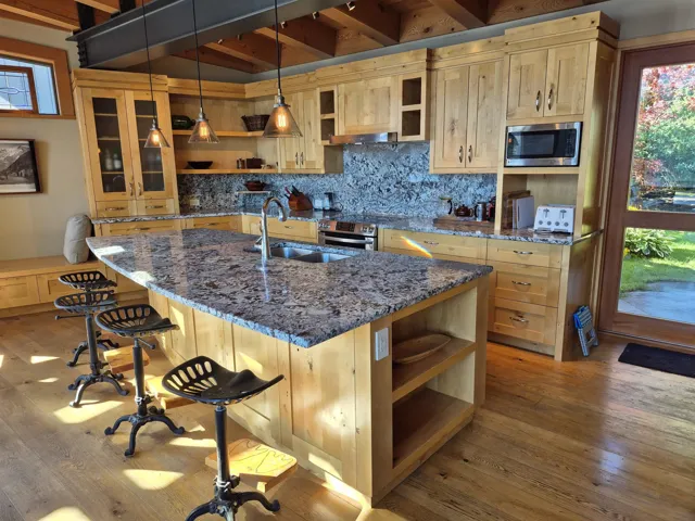 Kitchen featuring open shelves, glass insert cabinets, backsplash, dark stone countertops, and decorative light fixtures