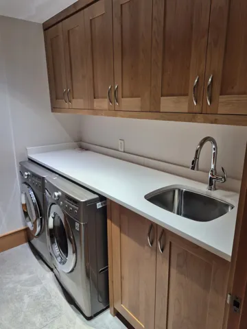 Laundry room with washer and dryer, cabinet space, and light tile patterned flooring