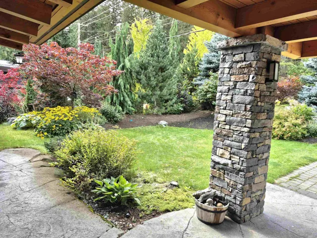 View of grassy yard with a patio area