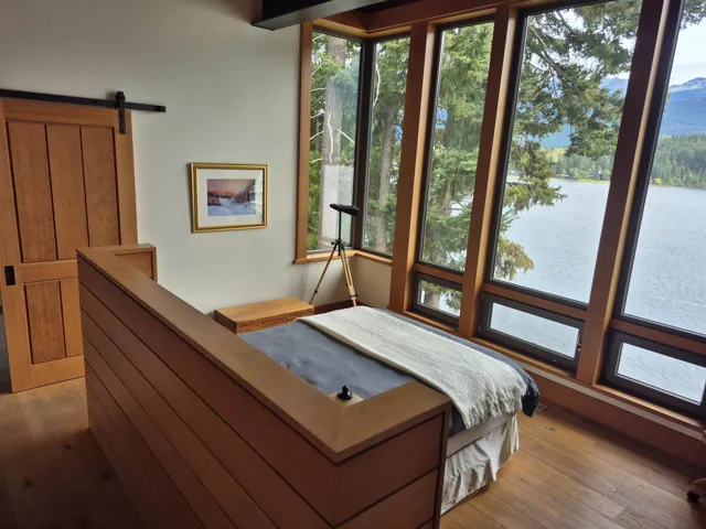 Bedroom with a barn door, wood-type flooring, and a water view