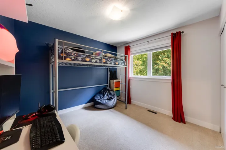 Bedroom featuring carpet floors, baseboards, and a textured ceiling