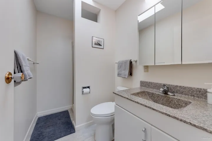 Bathroom with vanity, toilet, and baseboards