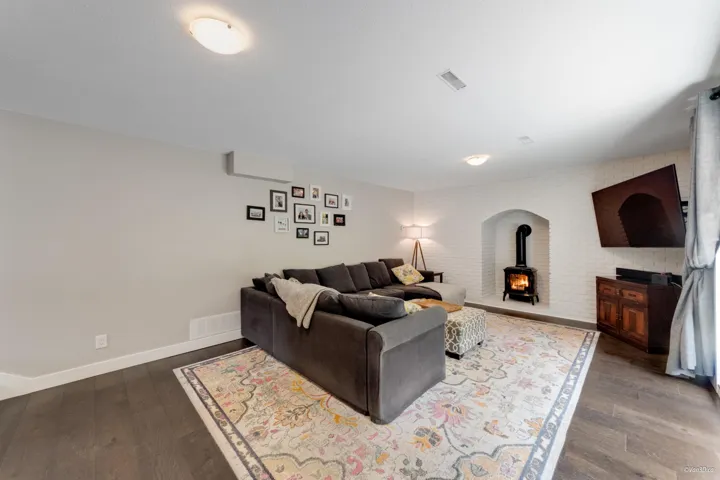 Living room featuring a wood stove, wood finished floors, and baseboards