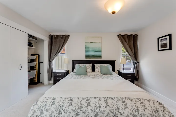 Bedroom with light colored carpet, baseboards, and a closet
