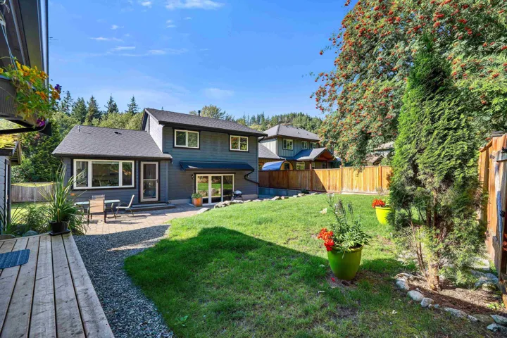 Expansive backyard featuring a lush lawn, gravel walkway, and a spacious paver patio