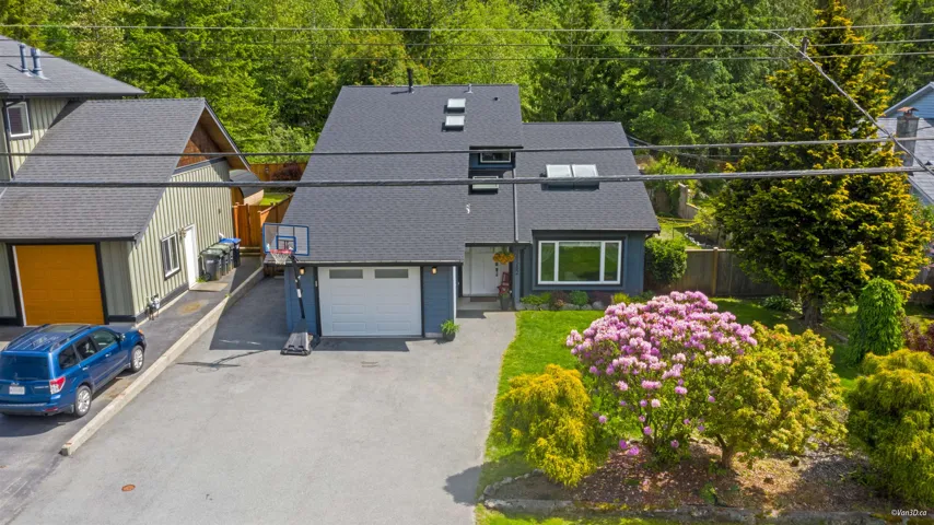 View of front of home featuring driveway and a shingled roof