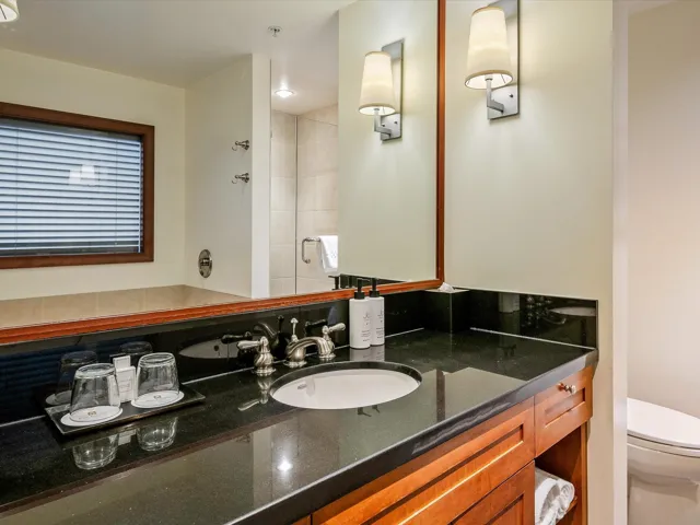 Bathroom featuring toilet, tiled shower, and vanity