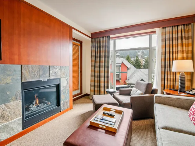 Living area with baseboards, a glass covered fireplace, and carpet floors