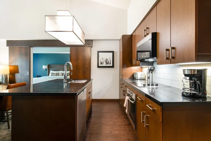 Kitchen featuring appliances with stainless steel finishes, a sink, dark wood-style floors, baseboards, and decorative backsplash