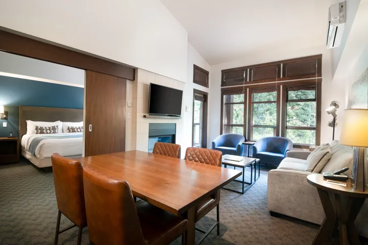 Dining space with dark colored carpet, high vaulted ceiling, and an AC wall unit