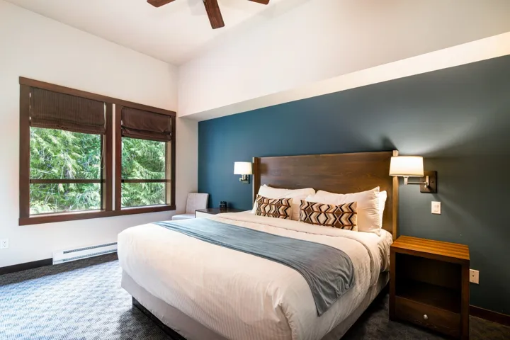 Carpeted bedroom with a baseboard heating unit, baseboards, and a ceiling fan