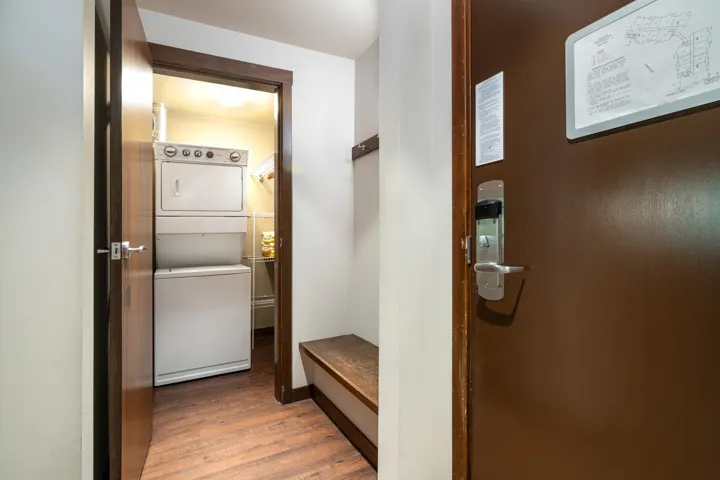 Mudroom featuring stacked washer / drying machine and wood finished floors