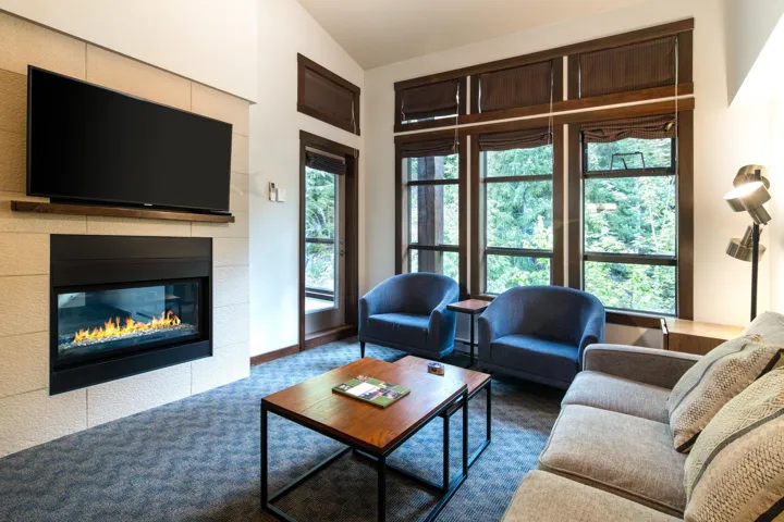 Carpeted living room with vaulted ceiling and a fireplace