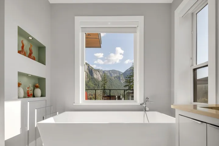 Full bathroom with a soaking tub, a mountain view, vanity, and built in shelves